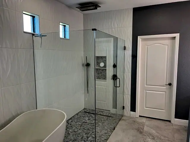 Modern bath with a freestanding tub and a frameless glass shower