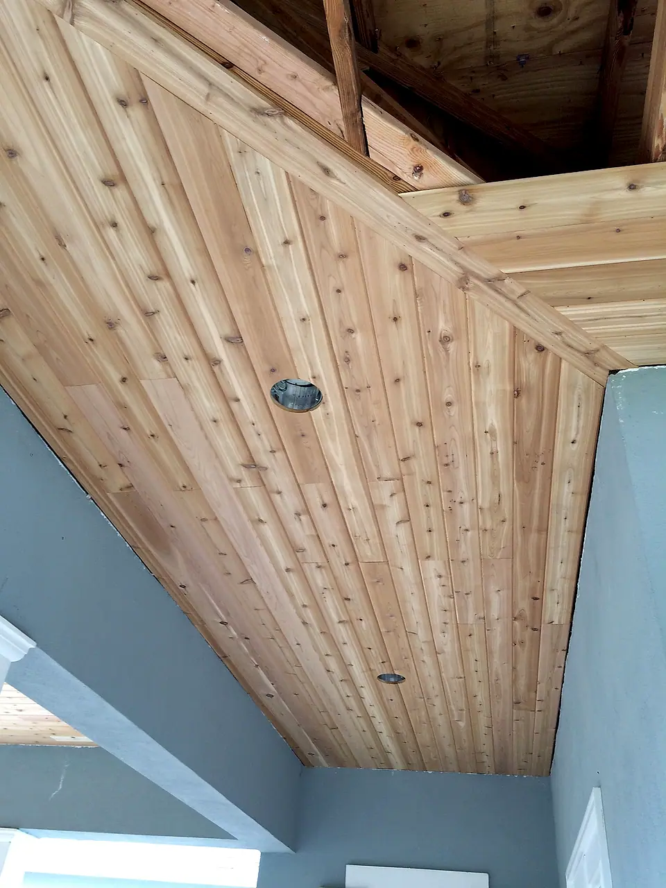 Cedar porch ceiling installed around recessed lights