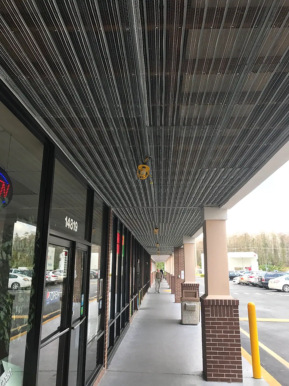 New metal ceiling going up along a storefront walkway