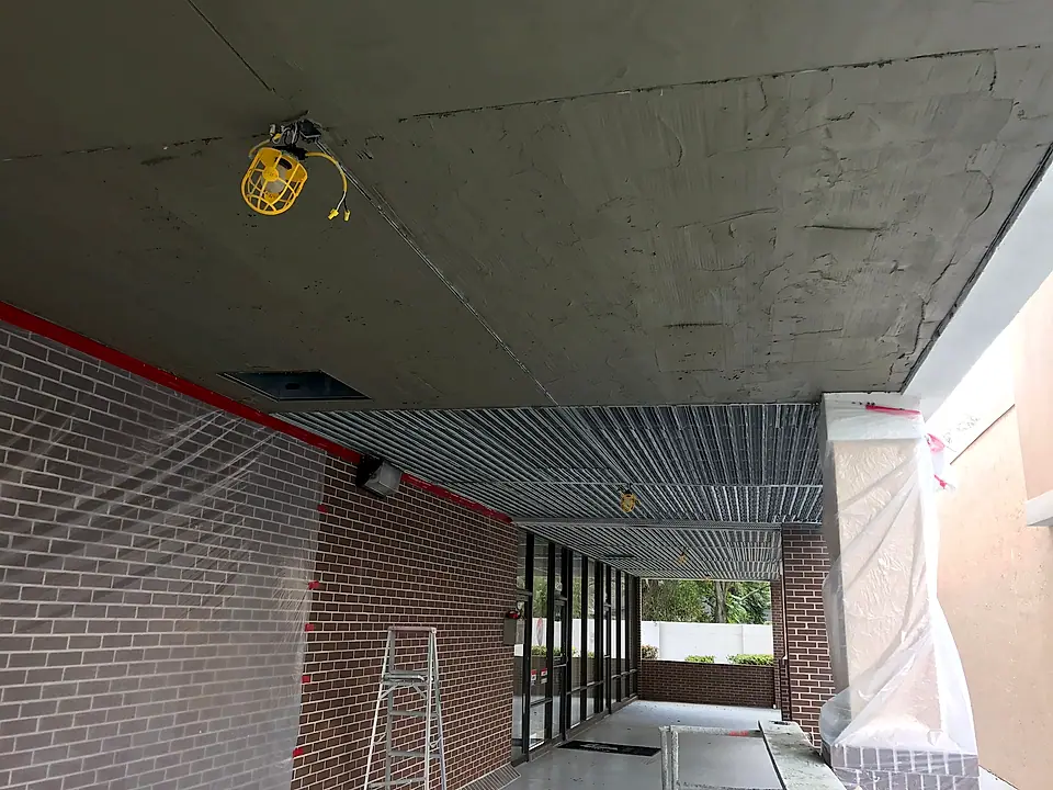 Walkway ceiling and columns opened up with plastic protecting the storefronts