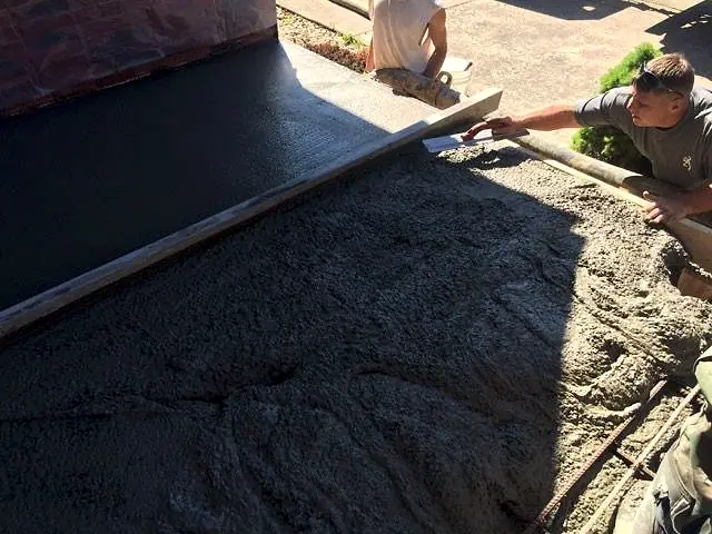 Crew screeding fresh concrete