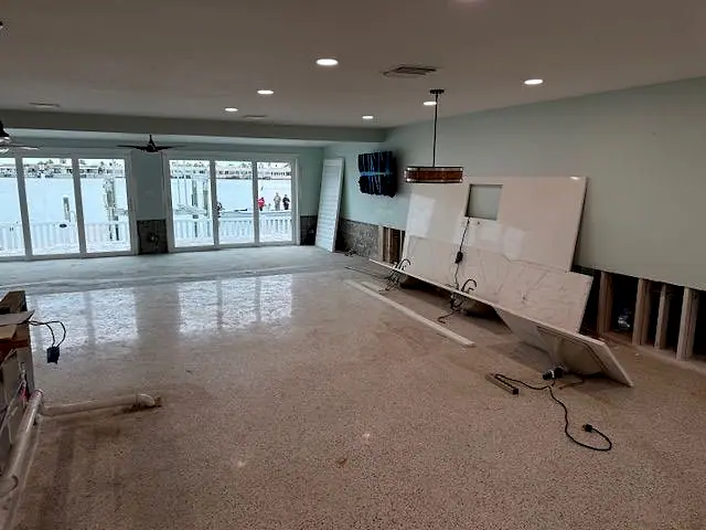 Great room with damaged lower walls cut out to the studs