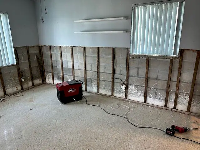 Wet wall opened to the block with a dehumidifier running
