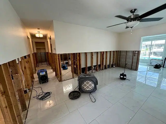 Air movers set in a hallway after the damaged drywall was removed