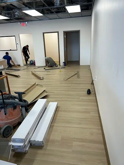 Crew laying plank flooring through an office suite
