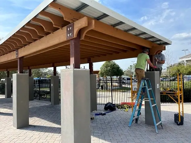Crew finishing the pavilion columns and timber framing
