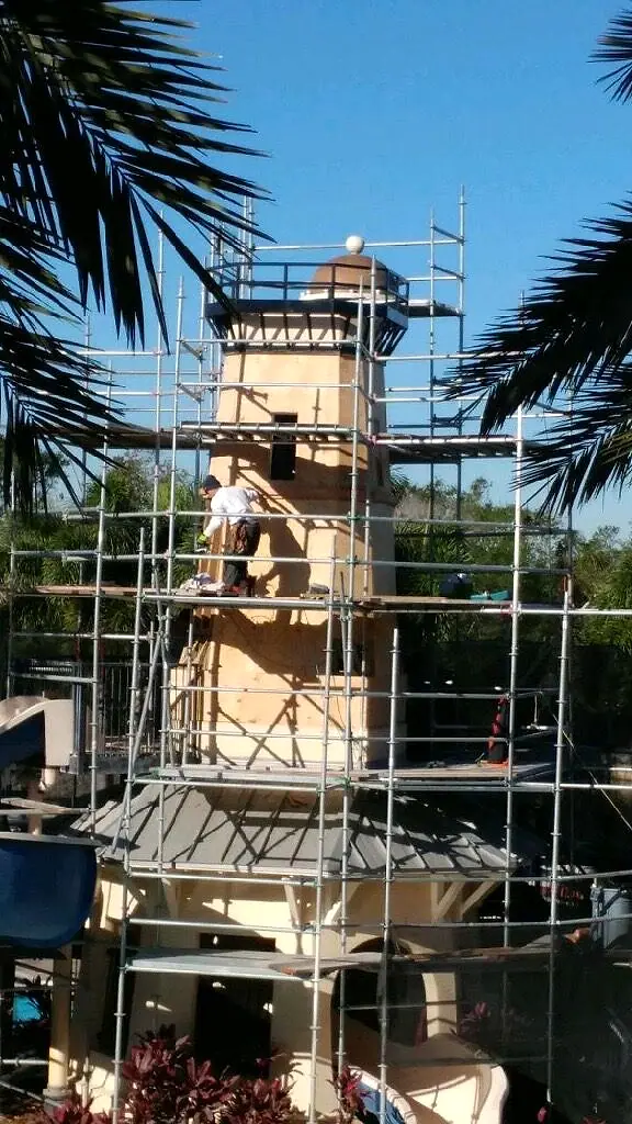 The tower wrapped in scaffolding with the crew on top