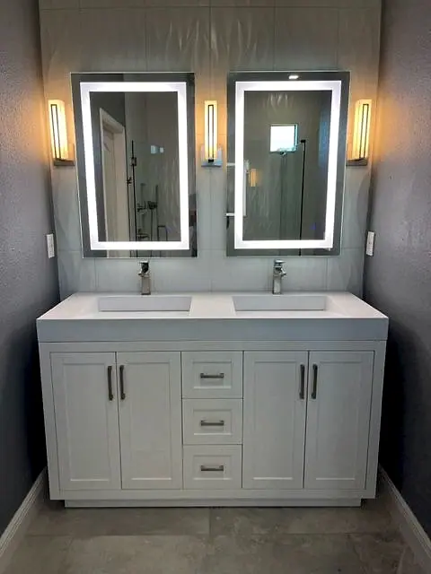 Double vanity with lighted mirrors and wall sconces