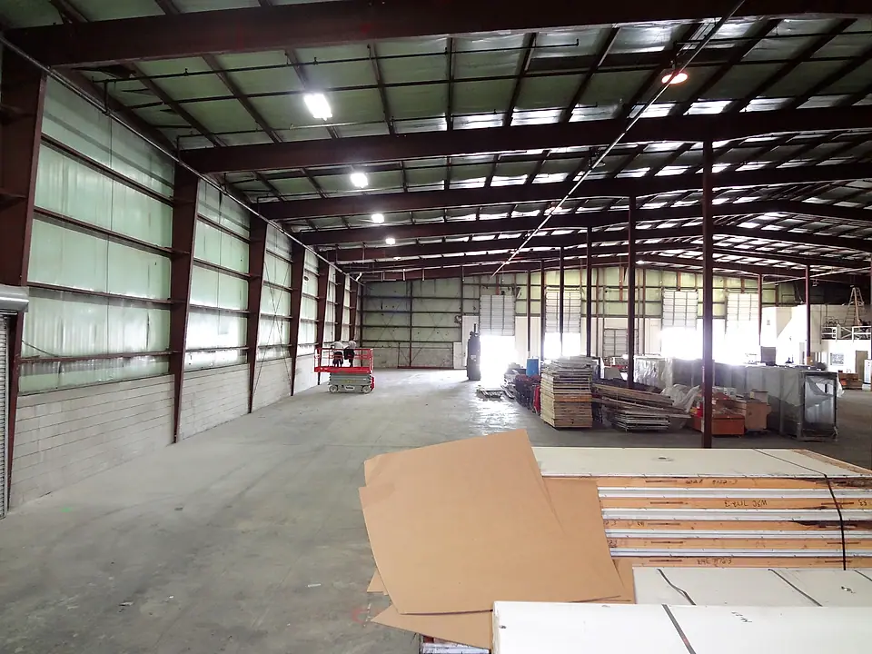 Materials staged in a large steel warehouse ready for build-out