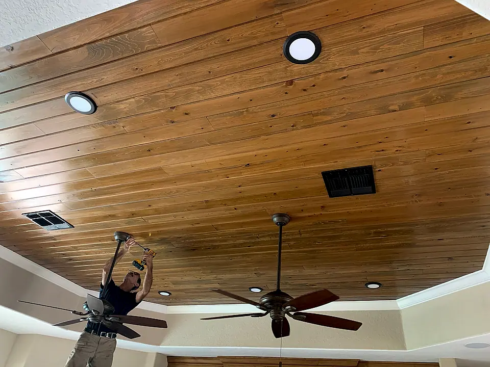 Crew installing a tongue-and-groove wood plank ceiling